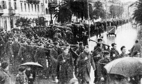 Borci 12. brigade promarširali su kroz gusti špalir građanstva preko Obale koja je usprkos kiši bila prepuna